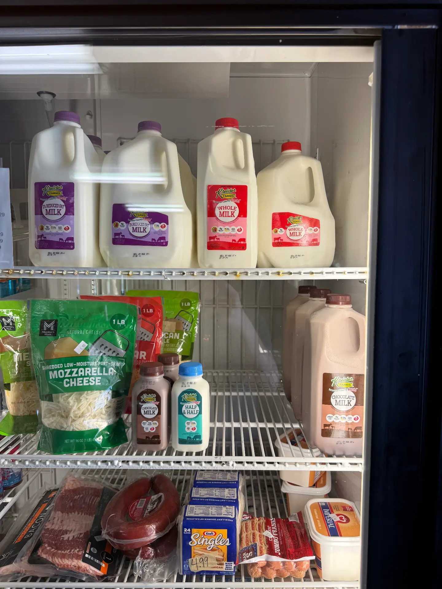Cooler stocked with milk, chocolate milk, cheese, eggs and bacon at the Lost Acres store