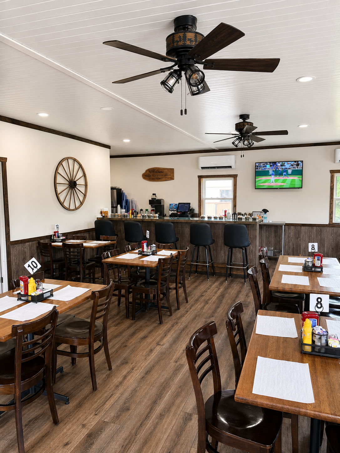 The Lost Acres Eatery dining room with wooden tables, wagon wheel decor and ceiling fans