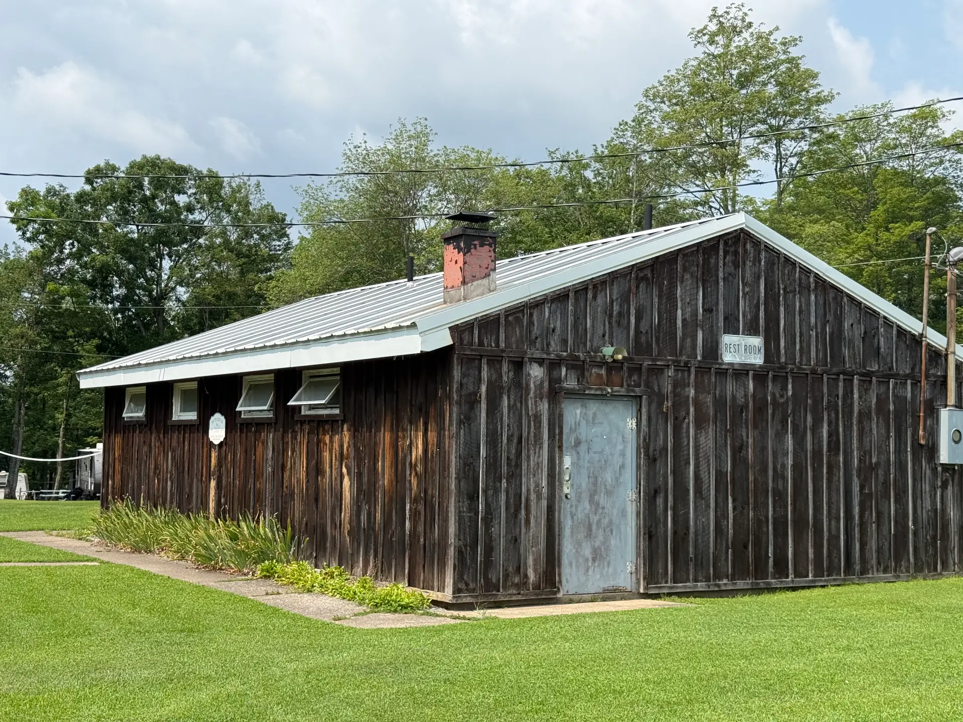 Rustic wood-sided bath house building on the grounds