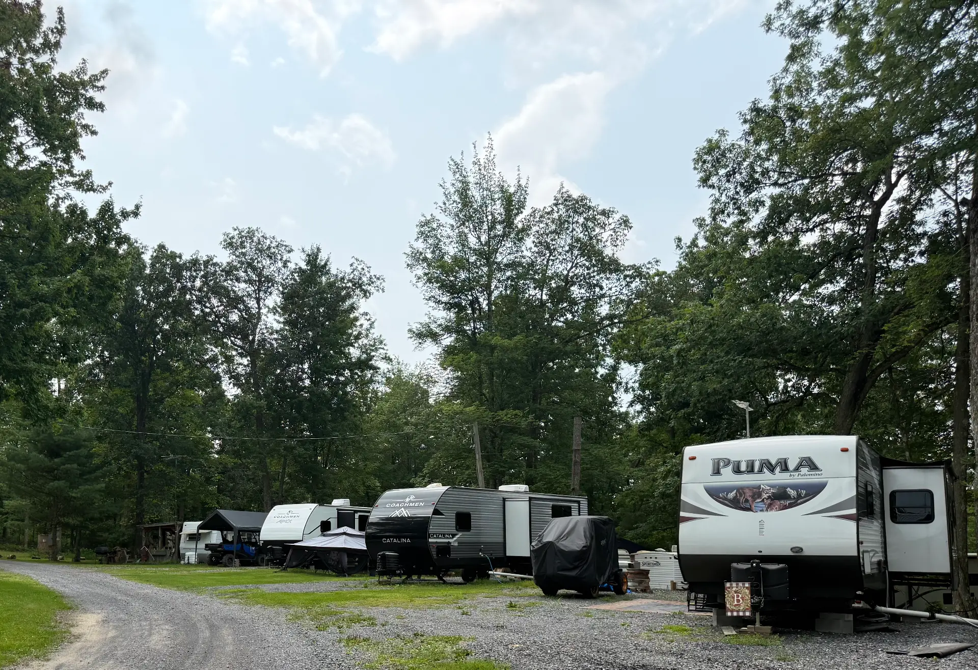 Row of seasonal campers parked along a gravel lane at Lost Acres
